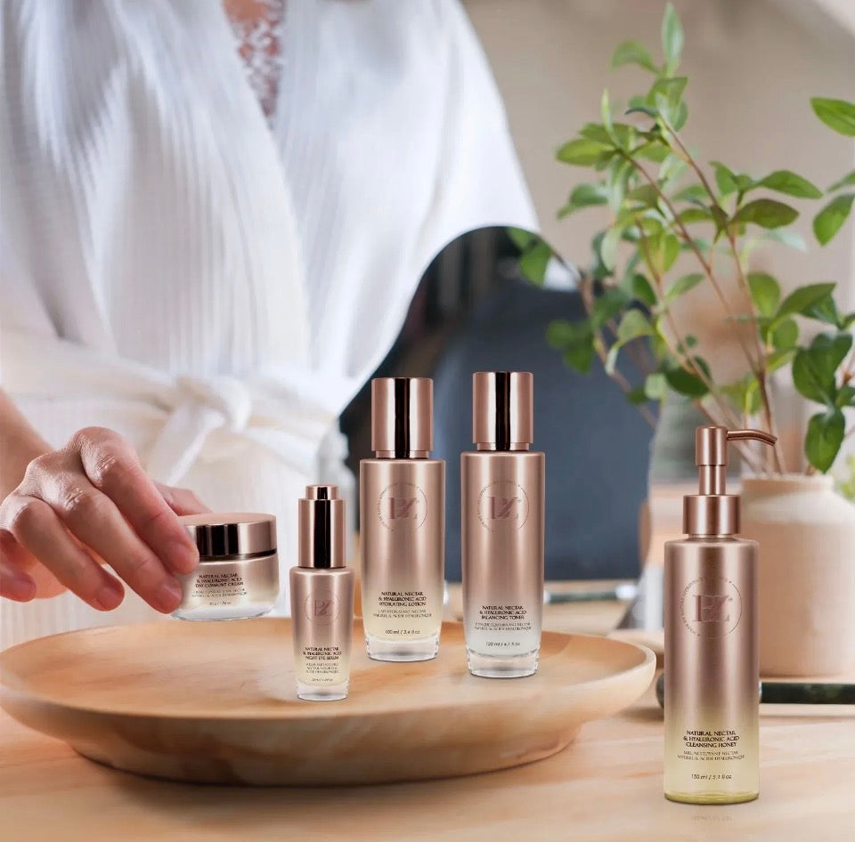 Model arranging BZ Natural Nectar & Hyaluronic Acid skincare collection on wooden tray - lifestyle shot