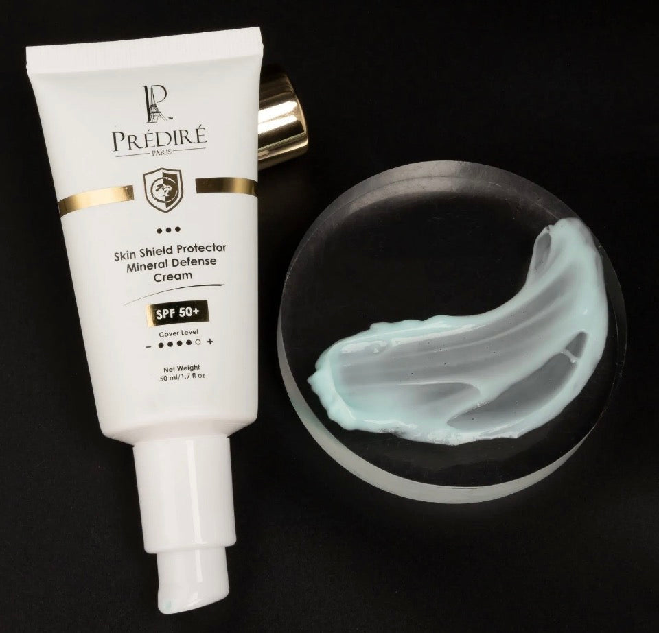Prédiré Paris Skin Shield SPF 50+ tube with blue mineral cream texture swatch on black background