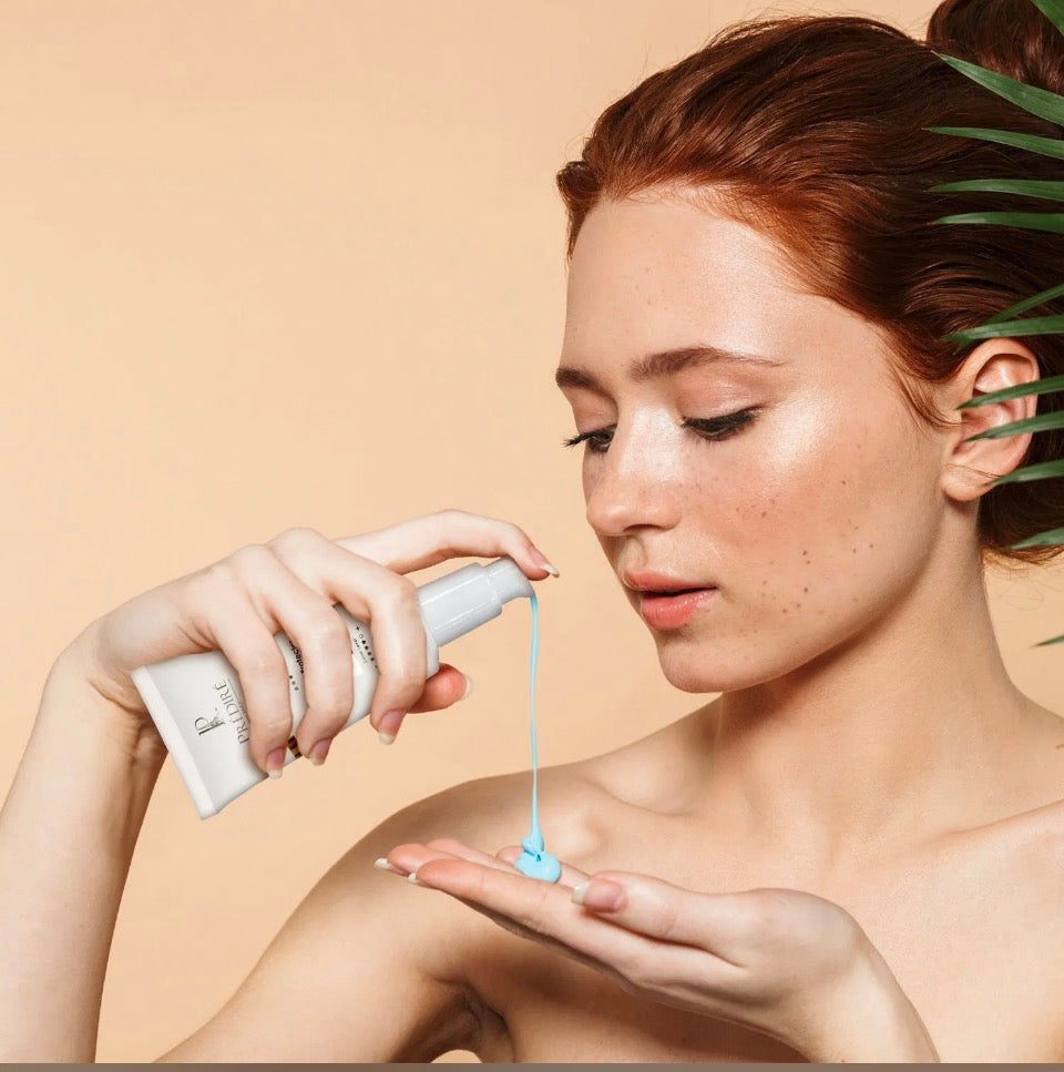 Model applying Prédiré Paris Skin Shield SPF 50+ cream to hand - blue mineral formula