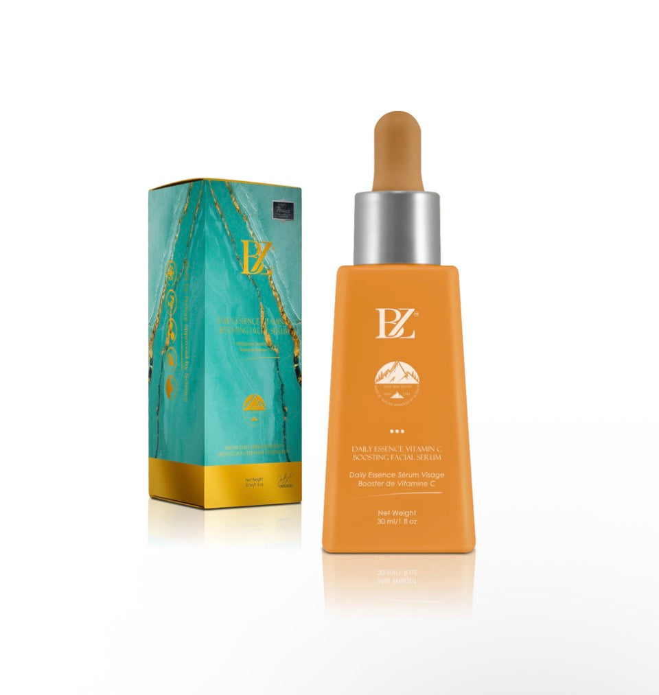 BZ Daily Essence Vitamin C Boosting Facial Serum - amber gold matte dropper bottle next to teal marble and gold gift box on white background